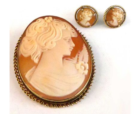 A 9ct yellow gold cameo brooch and earring set, the oval shell cameo brooch depicting a classical woman within a ropetwist su