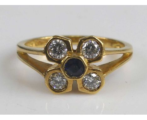 An 18ct yellow gold sapphire and diamond flower cluster ring, featuring a centre round sapphire surrounded by four round bril