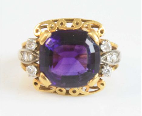 A yellow and white metal, amethyst and diamond dress ring, featuring a centre cushion cut amethyst with a quatrefoil of round