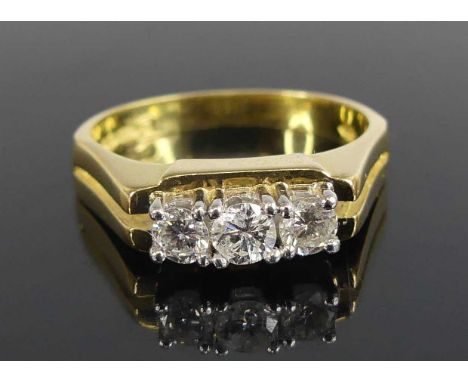 An 18ct yellow and white gold diamond three-stone ring, featuring three round brilliant cut diamonds in claw settings, diamon