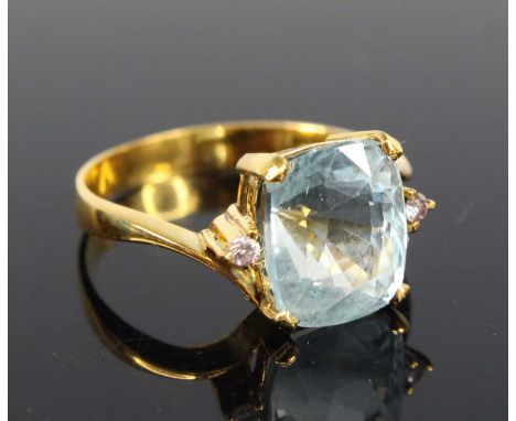 A contemporary yellow metal aquamarine and diamond dress ring, the four-claw set cushion cut aquamarine measuring 10.1 x 8.6 