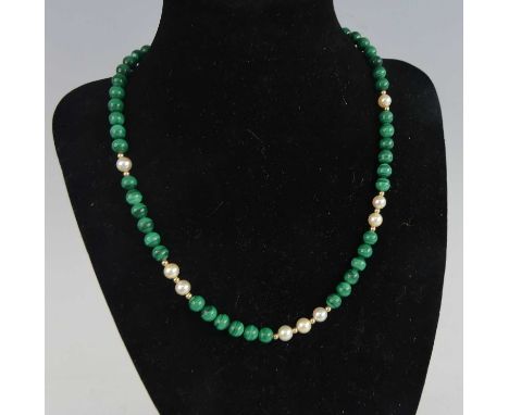 A beaded malachite and cultured pearl necklace, the pearls each further divided with small yellow metal beads, the whole on y