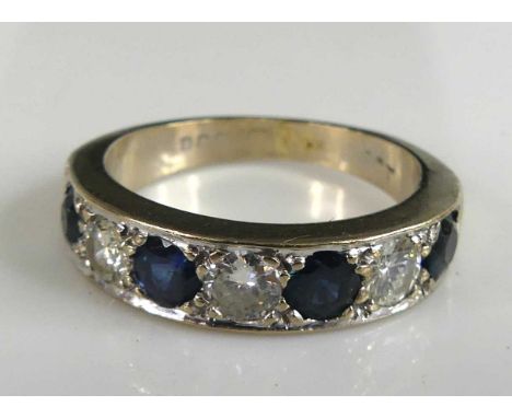 An 18ct white gold, sapphire and diamond half hoop eternity ring, featuring four round sapphires alternating with three round