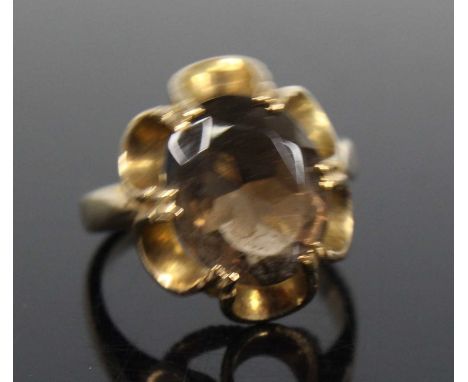 A yellow metal smoky quartz dress ring, featuring an oval faceted smoky quartz in a scalloped claw setting, smoky quartz dime