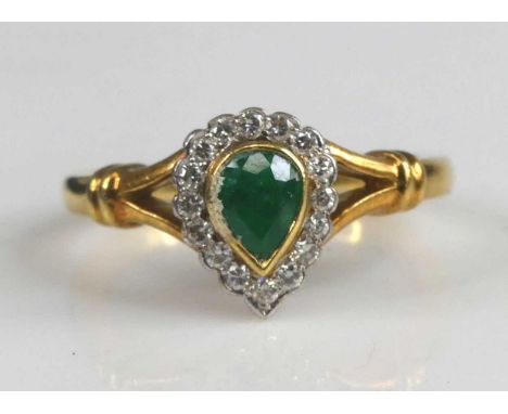 An 18ct yellow and white gold, emerald and diamond pear shaped cluster ring, having a pear cut emerald within a border of six