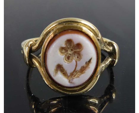 A yellow metal sardonyx dress ring - the 10.2 by 9.1mm oval sardonyx featuring an intaglio of a flower and mounted in a bezel