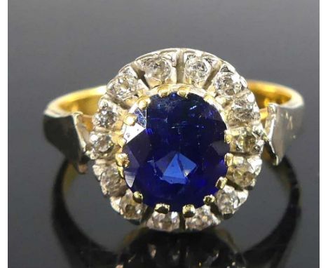 A 22ct yellow gold, sapphire and diamond oval cluster ring, having white metal detail to the shoulders, comprising an oval fa