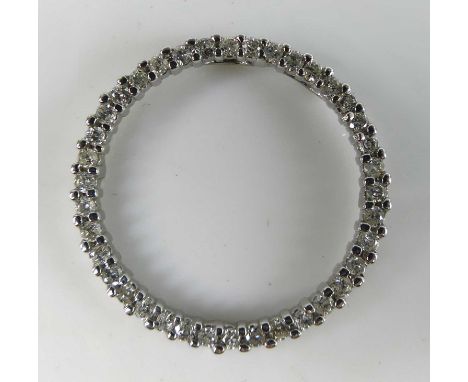 A contemporary white metal and diamond set circular pendant, arranged as a ring of 42 claw set small round cut diamonds, tota