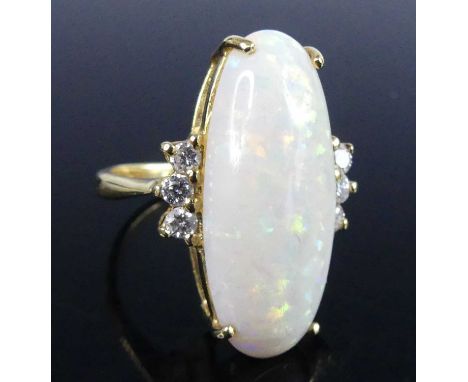 A modern 18ct gold opal and diamond set dress ring, the four claw set cabochon opal measuring approx 24 x 10.1 x 6.8mm, flank