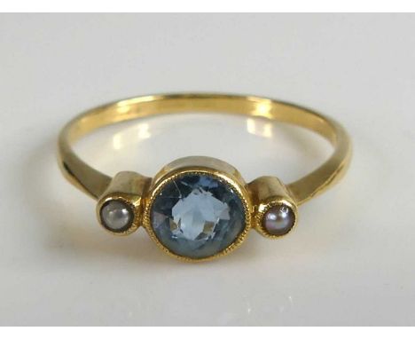 A yellow metal aquamarine and pearl 3 stone ring, the centre round aquamarine measuring 5.7 by 4.6mm and estimated as weighin