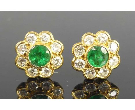 A pair of 18ct yellow gold emerald and diamond circular cluster earrings, each featuring a centre round emerald within a bord