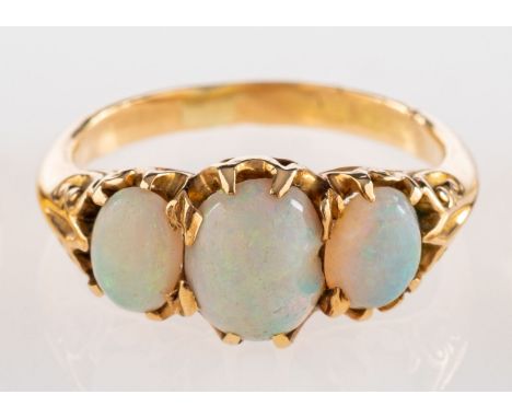 A three stone opal ring, set with three oval cabochon opals in claw settings, ring size O 1/2.




