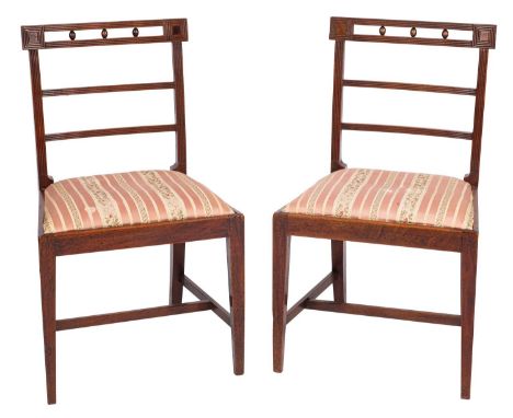 A pair of Regency mahogany side chairs, early 19th century; the reeded ladder backs each with three ovoid inserts, possibly c