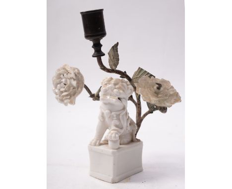 A Dehua blanc de chine lion dog  incense burner, remodelled as a candlestick (a/f).
