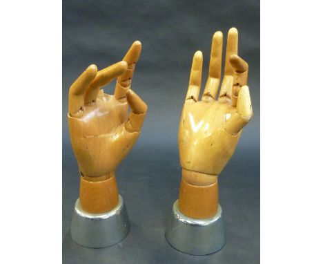 A PAIR OF WOODEN ARTISTS MODELS OF HANDS, with articulated digits and wrist, on chromed bases, height 28cm (2) Condition:lack