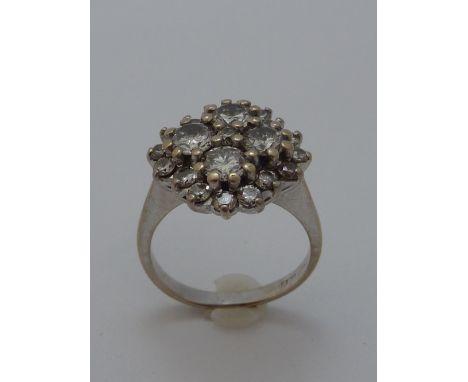 A DIAMOND RING, with central brilliant cut diamond surrounded by four larger brilliant-cut diamonds forming a cross-shape to 