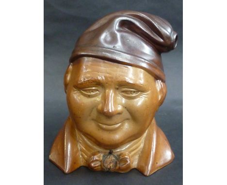 A 19TH CENTURY SALT GLAZED STONEWARE SPIRIT FLASK, modelled as the head of a smiling man, he wears a cloth cap and bow tie, t