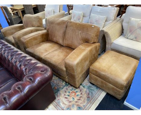 A tan leather sofa, armchair and footstool