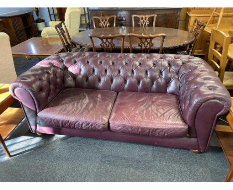 A maroon leather Chesterfield two seater sofa