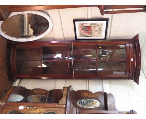 A 1930s mahogany corner cabinet, the dentil cavetto moulded cornice over a long glazed door on bracket feet, 189cm high, 70cm