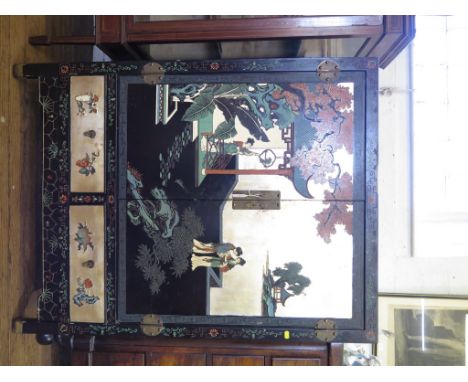 A painted and lacquered Oriental cabinet, depicting figures and birds in garden scenes, the pair of cupboard doors enclosing 