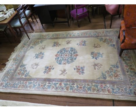 A Chinese wool carpet, the ivory ground with floral sprays within a floral scroll border 306cm x 187cm