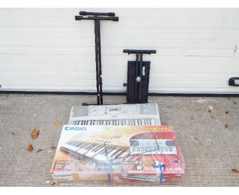 Yamaha and Casio Keyboards with Stands and seat. Casio LK Lighting Keyboard in box, S.N 5018219ZN. Yamaha PSR E303 unboxed bu