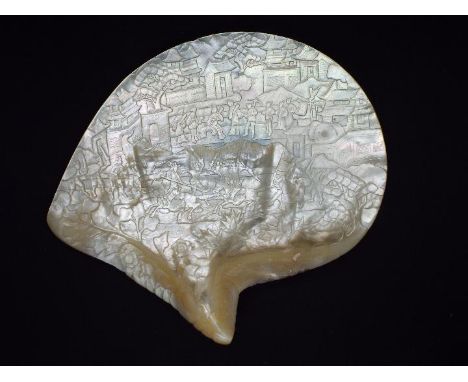 A Chinese mother of pearl shell carving depicting a battle scene with a background of buildings in a mountainous landscape, a