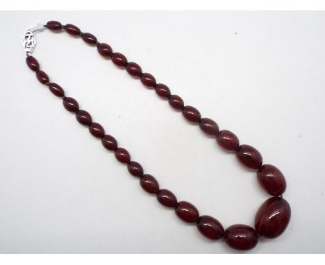 A graduated cherry amber bead necklace with 29 beads ranging from 1 cm (l) to 2.8 cm (l), 46 cm total length and 46 grams.. (
