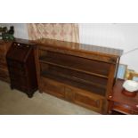 A carved oak bookcase with fitted cupboard below