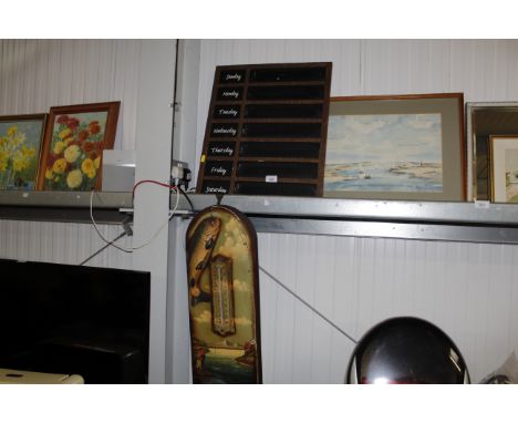 A chalk board marked with days of the week and a fishing related thermometer