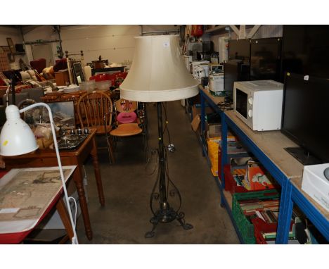 An ornate metal standard lamp and shade