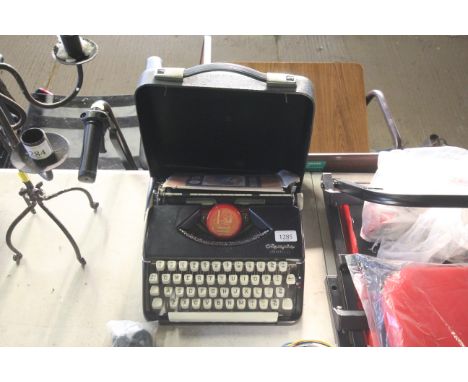 An Olympia Splendid 66 cased typewriter and packet of typewriting paper
