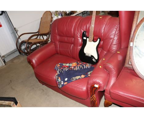 A red upholstered two seater sofa