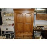 A modern pine two door wardrobe fitted two drawers