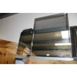 A framed wall mirror and a frameless bevel edged m