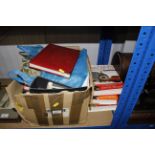A box containing various stamps and albums