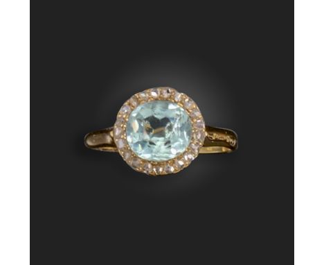 An Edwardian aquamarine and diamond cluster ring, the oval-shaped aquamarine is set within a surround of rose-cut diamonds in
