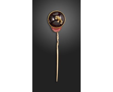 A late 19th century jockey cap stick pin, mounted with a cabochon garnet centred with a diamond and twisted gold tassel, with