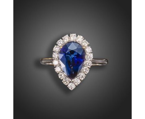 A sapphire and diamond cluster ring, the pear-shaped sapphire weighs approximately 2.50cts, set within a surround of round br