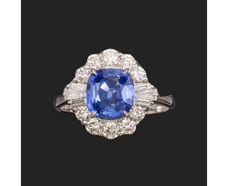 A sapphire and diamond ring, the cushion-shaped sapphire weighs approximately 2.50cts, set within a surround of round brillia