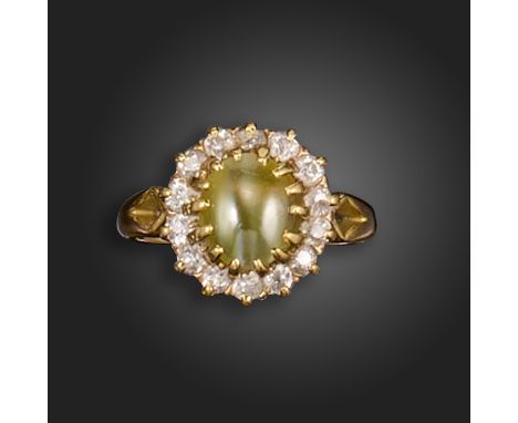 A chrysoberyl catseye and diamond cluster ring, the chyrsoberyl cabochon set within a surround of old circular-cut diamonds i