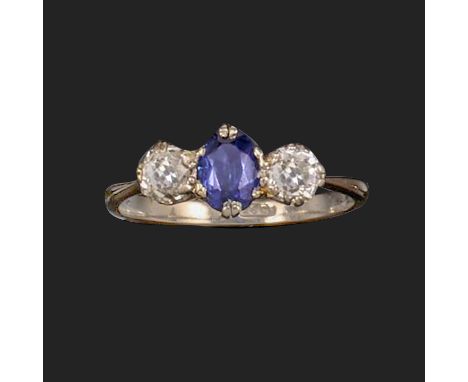 A synthetic sapphire and diamond ring, early 20th century, set with an oval synthetic sapphire between a pair of cushion-shap