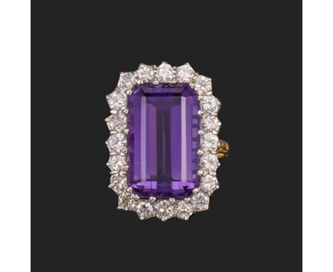 An amethyst and diamond cluster ring, set with an emerald-cut amethyst within a surround of round brilliant-cut diamonds in t