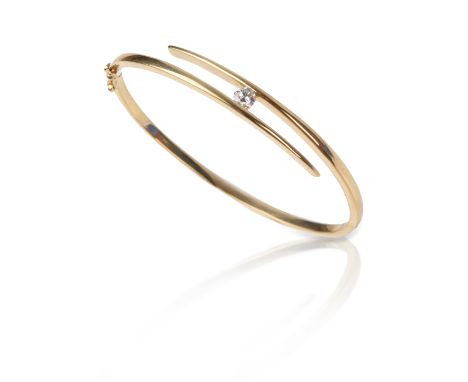 A diamond-set gold bangle, of crossover design, set with a brilliant-cut diamond weighing approximately 0.40cts, stamped 750,