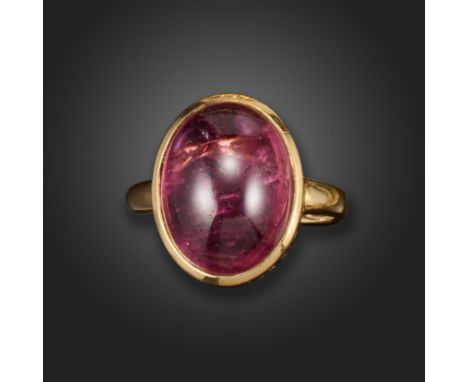 A tourmaline ring, the pink oval cabochon is rubover-set with pierced decoration to the gallery in gold, size N