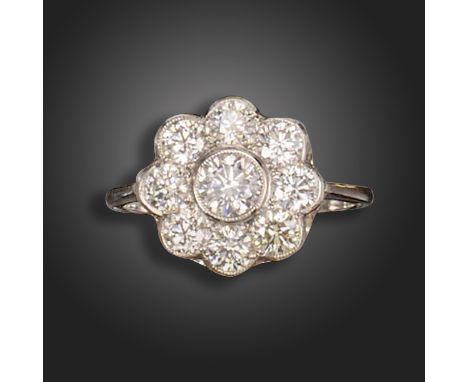 A diamond cluster ring, the flowerhead cluster rubover-set with round brilliant-cut diamonds in platinum, size N 1/2