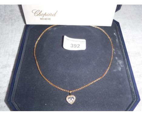 CHOPARD: A HEART-SHAPED PENDANT attached to a yellow metal fine link chain in a fitted presentation case and outer card box, 