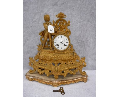 A FRENCH GILT METAL MANTEL CLOCK with a boy holding a bird cage on a giltwood base 