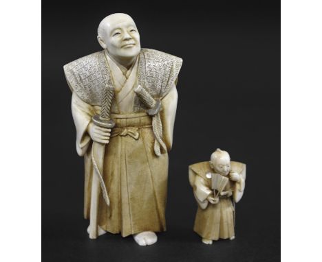 JAPANESE SIGNED IVORY OKIMONO - OKUBO Meiji period, a detailed carved ivory of a gentleman, holding one sword in one hand wit